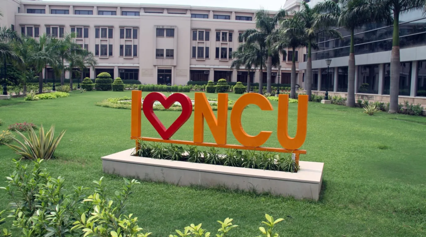 The NorthCap University campus lawn featuring the vibrant 'I Heart NCU' landmark sign